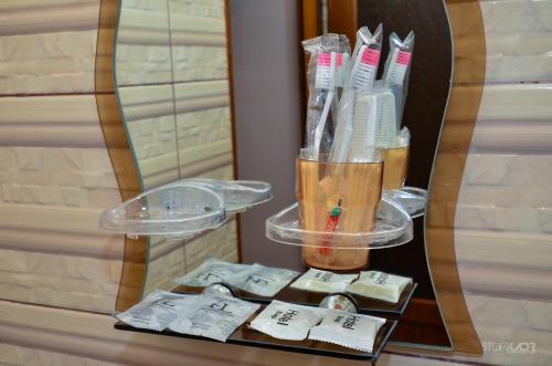 a table with a cup of toothbrushes and a mirror at Narek B&B in Goris