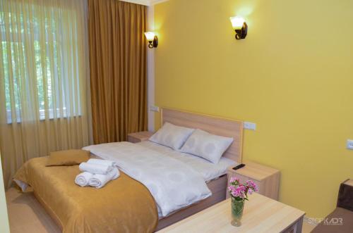 a bedroom with two beds and a table with towels at Narek B&B in Goris