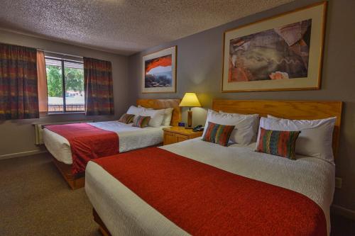 Habitación de hotel con 2 camas y ventana en Rustic Inn, en Moab