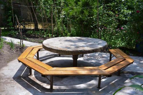 a wooden table and a bench with a table and a table and a table at Narek B&B in Goris