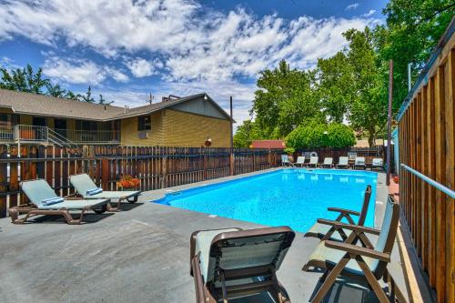 a swimming pool with two chairs and a wooden fence at Rustic Inn in Moab