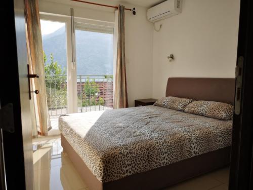 a bedroom with a bed in front of a window at Apartments Montenegro Risan Čučković in Risan