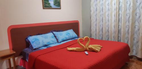 a red bed with a pretzel sitting on top of it at Hospedaje Germania in Puerto Ayora
