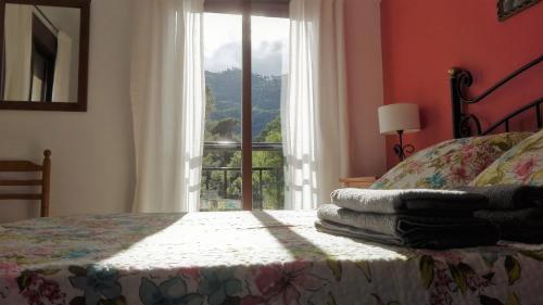 een slaapkamer met een bed en een raam met uitzicht bij EL JABALÍ CONTENTO in Arroyo Frio