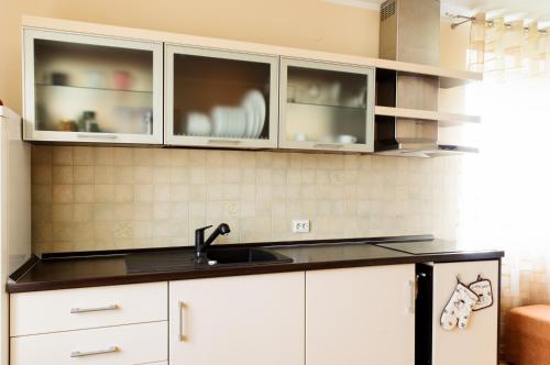 a kitchen with white cabinets and a sink at Jūratės B&B Namai in Karmėlava