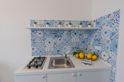 a kitchen with a sink and blue and white tiles at Casa Azulejos in Maiori