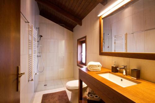 a bathroom with a sink and a toilet and a mirror at Quinta de Lograssol in Mealhada