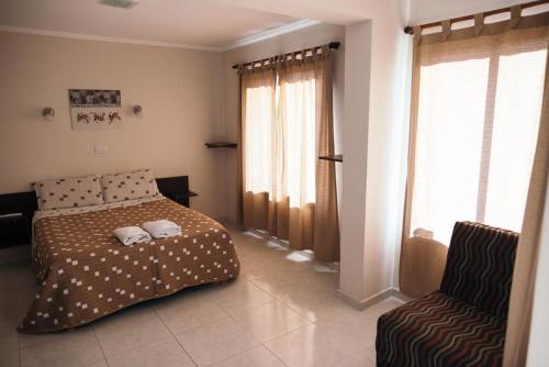a bedroom with a bed and a chair at Rincon Secreto in San Rafael