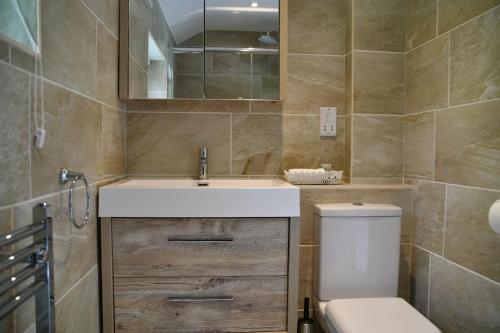 uma casa de banho com um lavatório e um WC em TREWASSICK BARN em Newquay