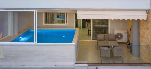a house with a swimming pool and two chairs at Grand Suites with Private Pools in Kalamata