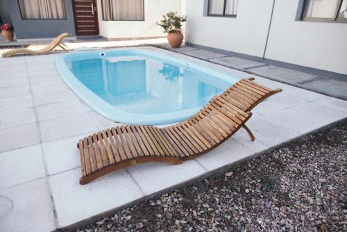 a wooden bench sitting next to a swimming pool at Rincon Secreto in San Rafael