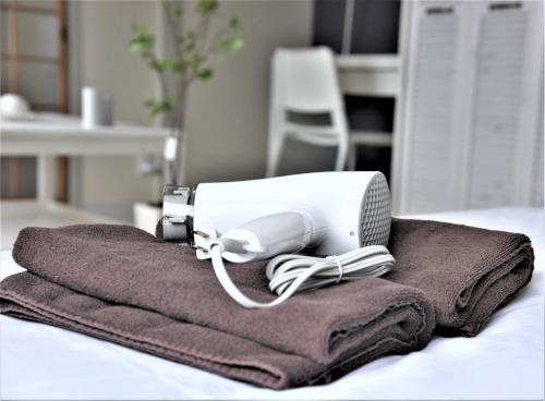 um secador de cabelo sentado em cima de uma pilha de toalhas em Kamiyama Mansion / Vacation STAY 4358 em Osaka