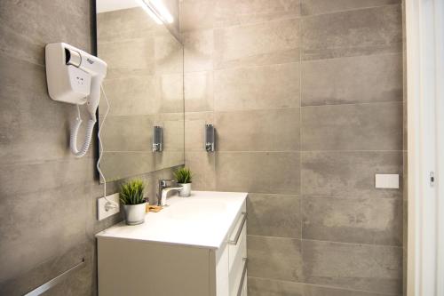 y baño con lavabo y ducha. en LA QUADRA SUITES - Central Apartments in Iseo, en Iseo