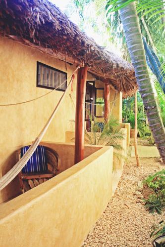a house with a hammock in front of it at Hotel Barrio Latino in Playa del Carmen