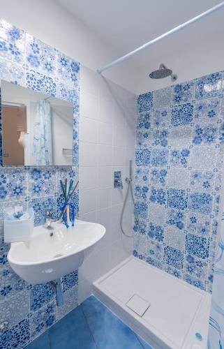 a blue and white bathroom with a sink and a shower at Casa Azulejos in Maiori