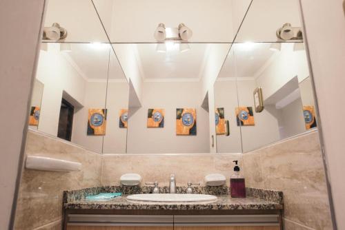 baño con lavabo y espejo grande en Rincon Secreto en San Rafael