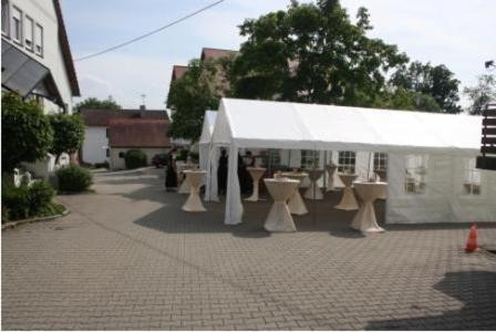 a white tent with tables and chairs in a street at Landgasthof Haagen in Schwabhausen bei Dachau