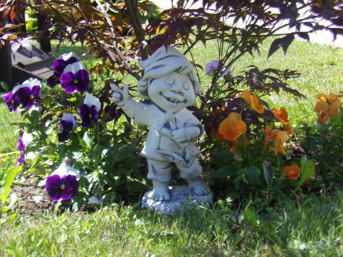 a statue of a child in a garden with flowers at Agroturystyka Nad strumykiem in Leśna