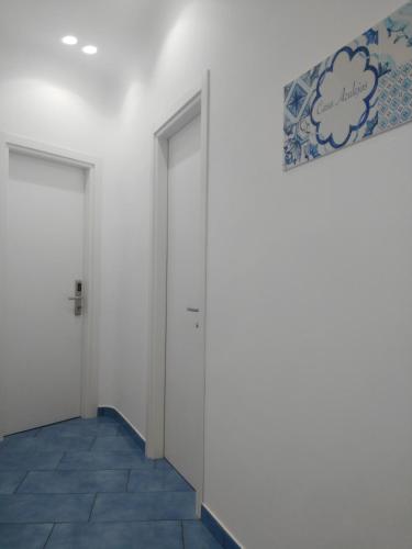 a hallway with two doors and a tile floor at Casa Azulejos in Maiori