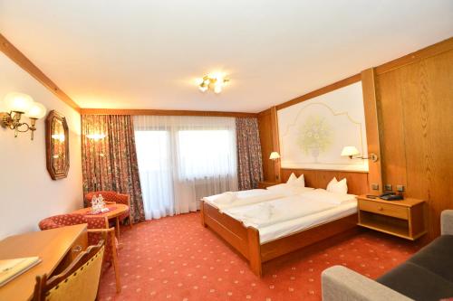 ゼーフェルト・イン・チロルにあるホテル レジデンツ ホックランド のベッドルーム1室(白い大型ベッド1台付)