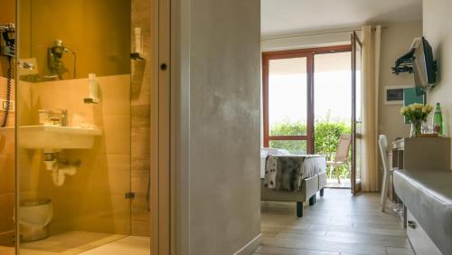 ein Badezimmer mit einer Glastür, die zu einem Schlafzimmer führt. in der Unterkunft Hotel Relais Agli Olivi in Lazise