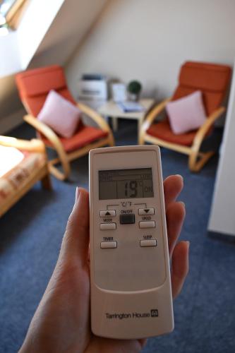 a person holding a remote control in a room at Pension Růžák in Růžová