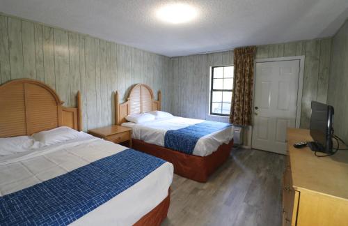 um quarto de hotel com duas camas e uma televisão de ecrã plano em Bishop Inn Downtown Gatlinburg em Gatlinburg