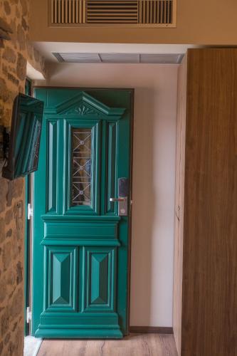 a green door with a window in a room at Hotel Arhontiko Vourloka in Pramanta