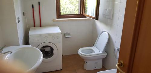 a small bathroom with a toilet and a washing machine at Stella fiorita in Panicarola