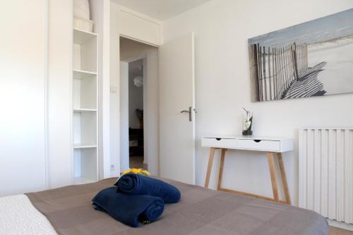 a bedroom with a bed with blue pillows on it at Résidence La Corvette in Toulon