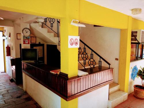 a store with a yellow wall and stairs in a building at Hotel Calendas in Salina Cruz