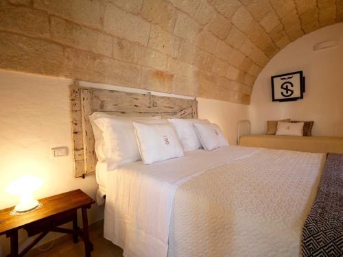 een slaapkamer met een bed en een tafel met een lamp bij Suite Sirene in Polignano a Mare