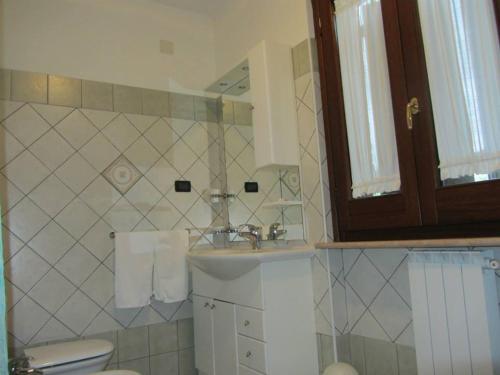 a bathroom with a sink and a toilet and a mirror at Il Melograno in Torino di Sangro