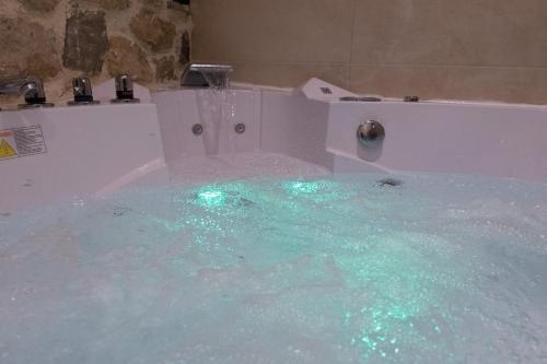 a bath tub filled with lots of blue water at Hotel Arhontiko Vourloka in Pramanta