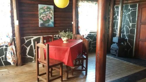 een eetkamer met een rode tafel en stoelen bij La Fontana de Tandil in Tandil