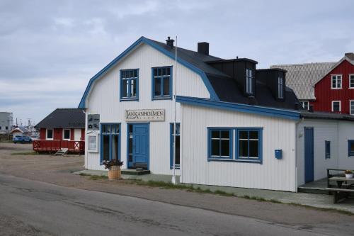 a white building with a blue roof on a street at Fredheimbrygga in Andenes