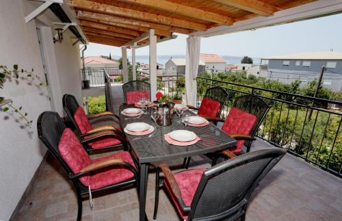 una mesa y sillas en el balcón de una casa en Apartments Rose, en Kaštela