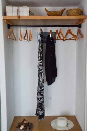 a closet with a shelf and a coat and shoes at Hawk Stone in Adamas