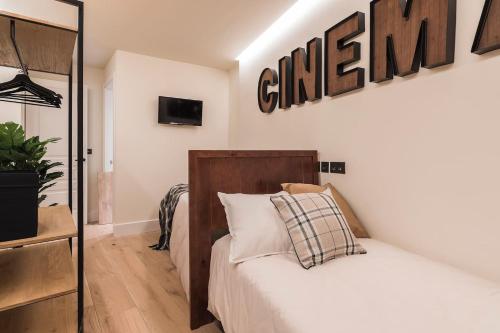 1 dormitorio con 1 cama y un cartel en la pared en Miribilla by Staynnapartments, en Bilbao