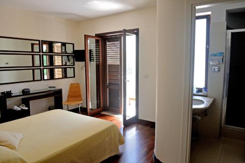 a bedroom with a bed and a bathroom with a sink at Hotel Le Piane in Villammare
