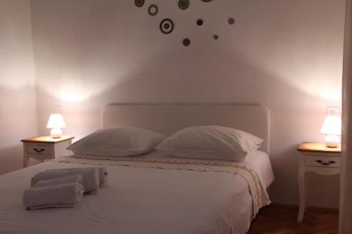 a bedroom with a white bed with two night stands at Petra Apartments in Korčula