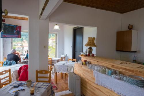 a kitchen with two tables and a counter in a room at Hotel Arhontiko Vourloka in Pramanta