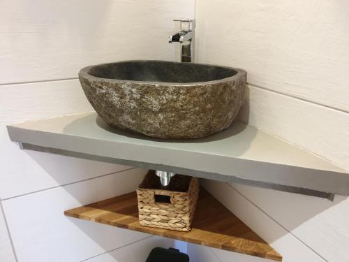 a bathroom with a stone sink on a shelf at Le Clos Marceau in Bédoin