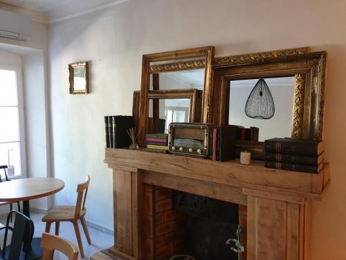 a fireplace with a mirror and an old radio on it at Le Clos Marceau in Bédoin