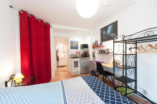 a bedroom with a bed and a red curtain at Studio au calme, dans village tranquille in Séné