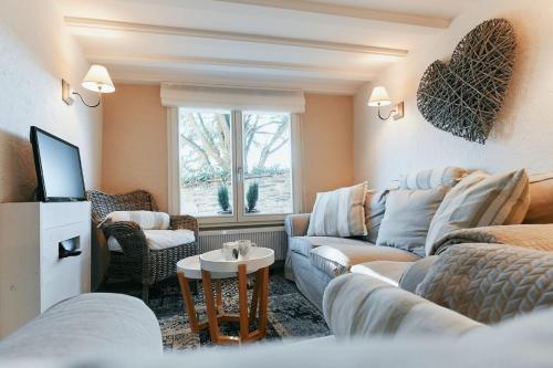 uma sala de estar com um sofá e uma televisão em Le Petit Gretedar em Malmedy