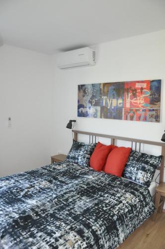 una camera da letto con un letto con cuscini rossi di Vas Lipa 7 -30 a Podcetrtek