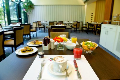 a table with plates of food and a cup of coffee at Mercure Reggio Emilia Centro Astoria in Reggio Emilia