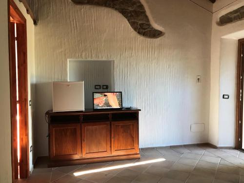 Cette chambre dispose d'une armoire en bois avec une photo. dans l'établissement Li Casacci, à Arzachena