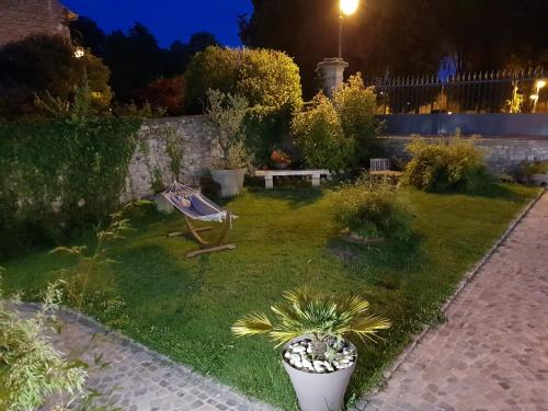a garden at night with a bench and plants at Le Gîte Senlisien in Senlis